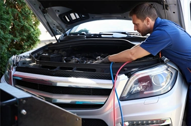 Man jump starting a battery of car