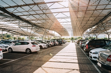 Covered vehicle storage facility with multiple cars parked in a secure, well-lit parking structure designed for safe long-term and short-term vehicle storage.